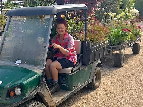 A member of the Hortus Loci team driving a buggy loaded with plants