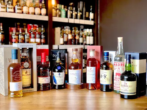 Bottles of whisky, rum and gin lined up on the counter and shelves at The Spirits Room