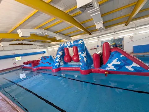 The indoor pool used by Swim Odiham, with an inflatable obstacle course on the water