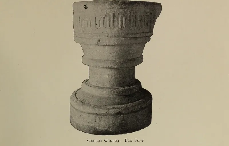 Old photograph of the stone font in All Saints' Church, Odiham, with lettering round the bowl